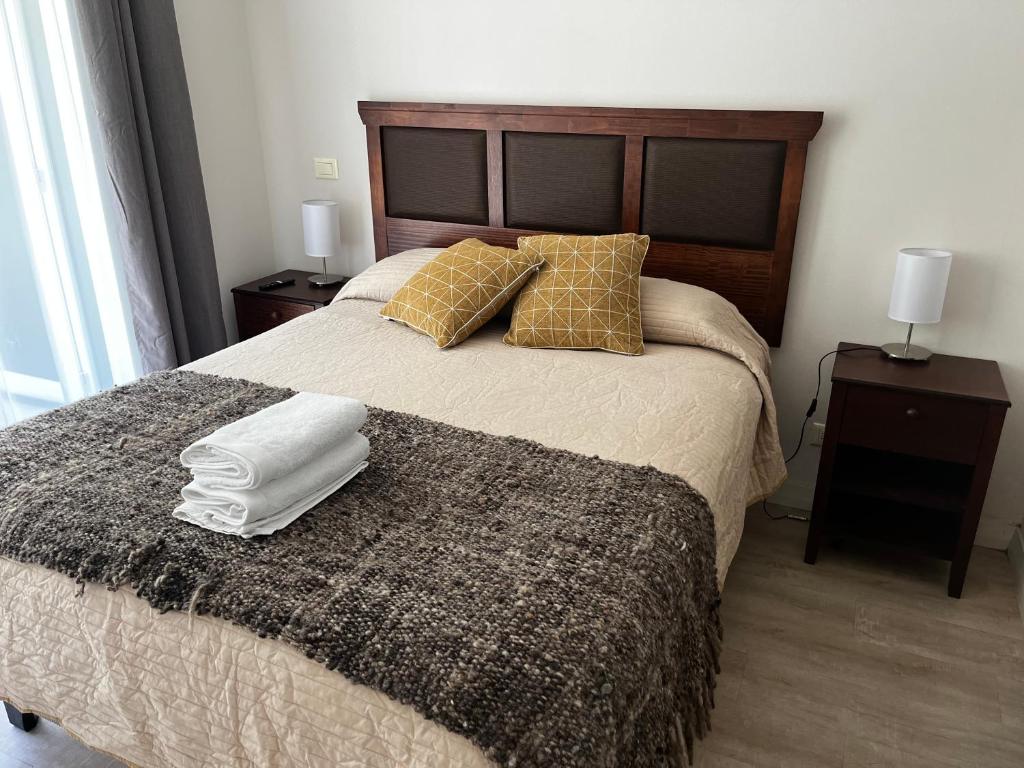 1 dormitorio con 1 cama con 2 almohadas y 1 manta en Departamento El Chiriwe, en Puerto Varas