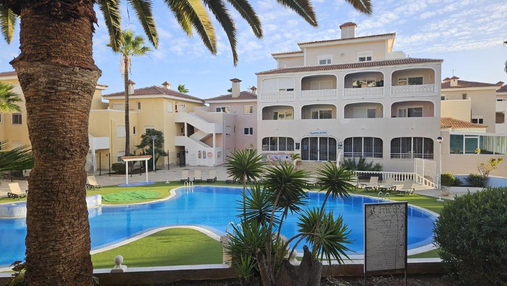 a large building with a swimming pool in front of a resort at Residencial Chayofa, 1 dormitorio in Chayofa