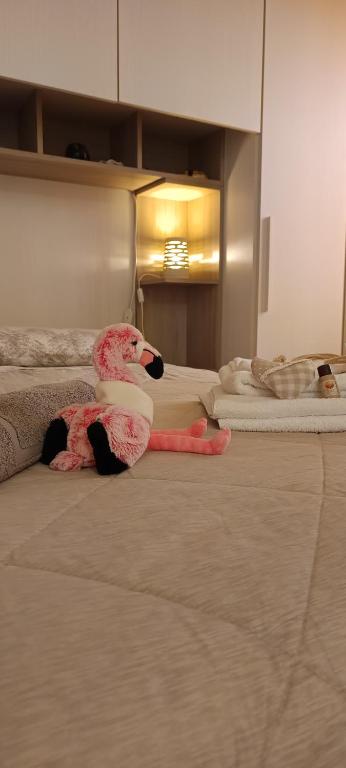 a pink stuffed animal laying on a bed at Casa Il Nido in Cagliari