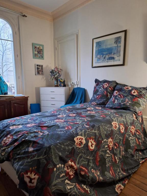 - une chambre avec un lit et une couverture colorée dans l'établissement Appartement de charme pres de Montmartre, à Paris