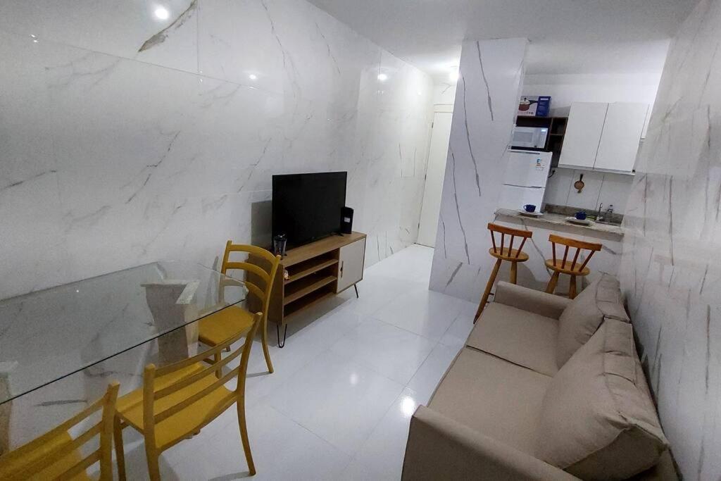 uma sala de estar com um sofá e uma mesa com cadeiras em Apto Familiar em Aracaju