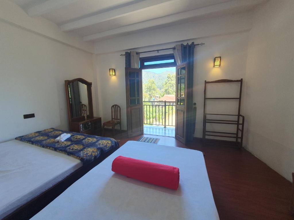 1 dormitorio con 2 camas y un objeto rojo sobre una mesa en Barrow Villa, en Nuwara Eliya