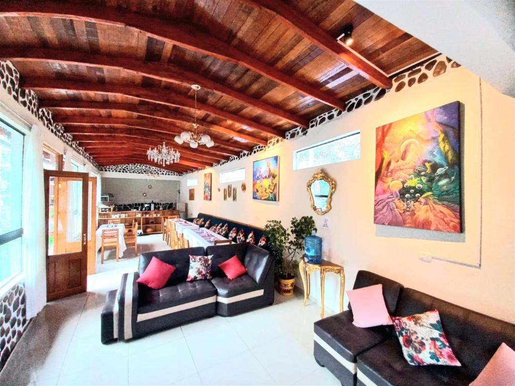 a living room with leather furniture and a wooden ceiling at Hotel Humantay Lodge Ollantaytambo in Ollantaytambo