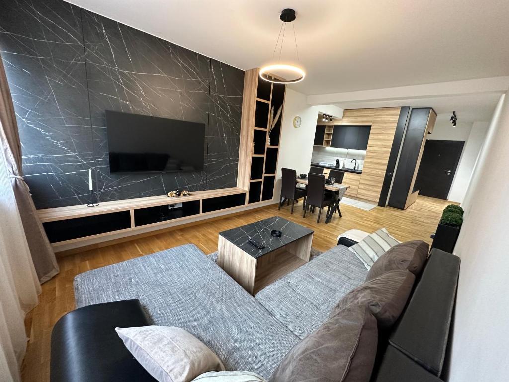 sala de estar con sofá y TV de pantalla plana en MAR Residence 5 en Niš