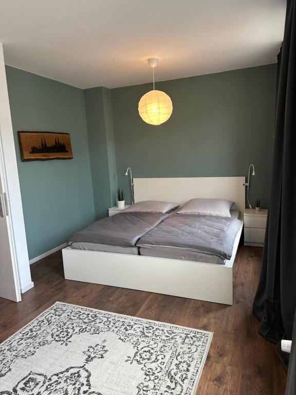 een slaapkamer met een bed en een blauwe muur bij Ferienwohnung Hansetraum Lübeck in Lübeck