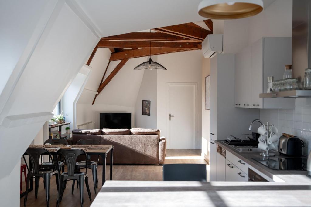 uma cozinha e sala de estar com um sofá e uma mesa em Chestnut House Appartment em Le Mée-sur-Seine