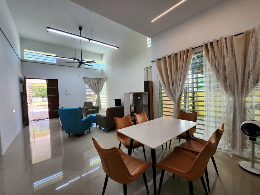 een eetkamer en een woonkamer met een tafel en stoelen bij 42 Klebang - KKS Plus Collection in Ipoh