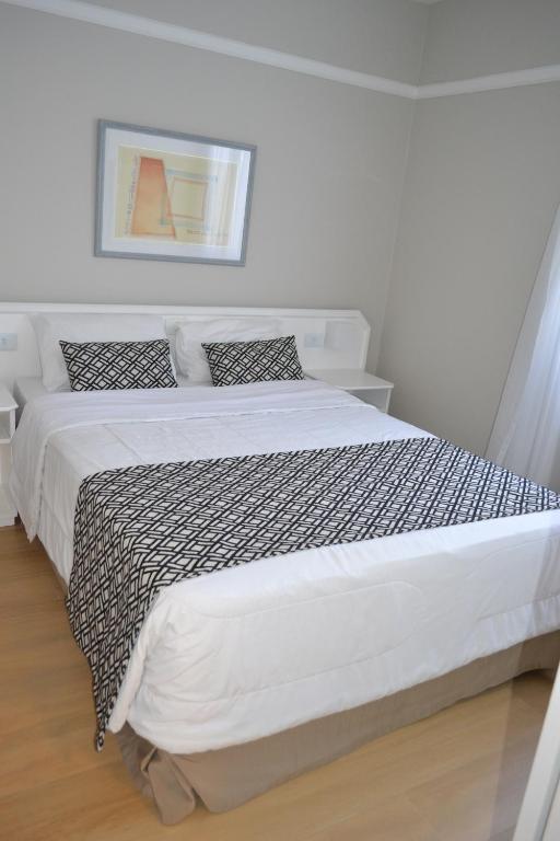 una camera bianca con un grande letto in una stanza di Flat Jardim Paulista a San Paolo