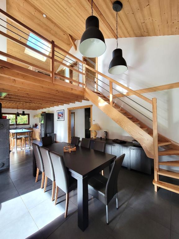 une salle à manger avec une table et des chaises et un escalier dans l'établissement Chalet des Jonquilles - Au calme, bordant la forêt, à Gerbépal
