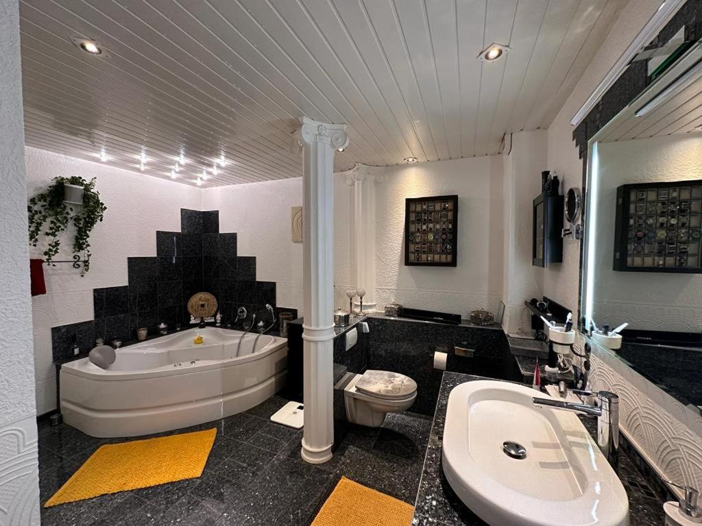a bathroom with a tub and a toilet and a sink at Das Haus am Kanal. in Lübeck