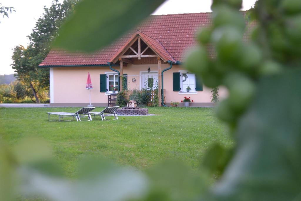 ein Haus mit zwei Stühlen im Hof in der Unterkunft Gästehaus Taucher in Bad Blumau