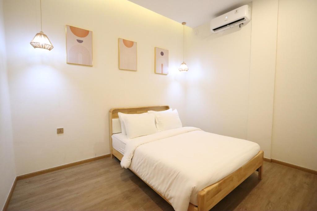 a bedroom with a bed with white sheets and pillows at Casabella 103 A2 Grand Batam Penuin Wet Market in Nagoya