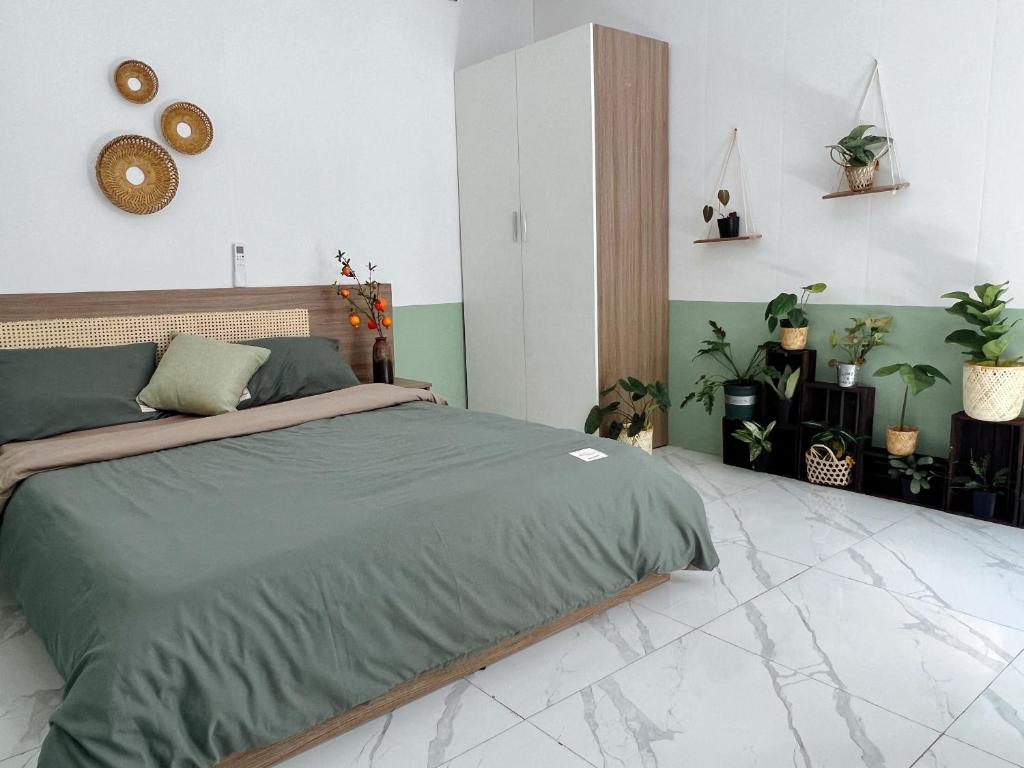 1 dormitorio con 1 cama en una habitación con plantas en The Hue Homestay, en Thôn Dương Xuân Hạ