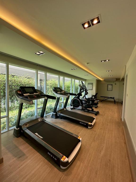a gym with several exercise bikes in a room with windows at East Ville-45 in Ban Hua Khao Sammuk