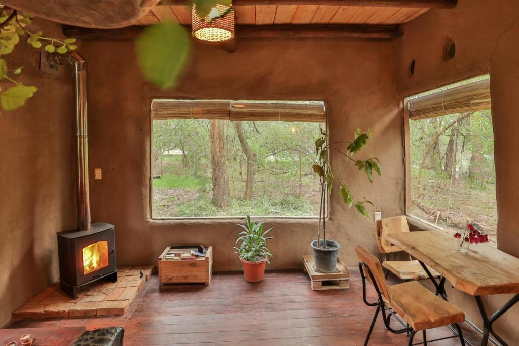 a living room with a woodburning stove and a table at Casa de barro in Santa Ana