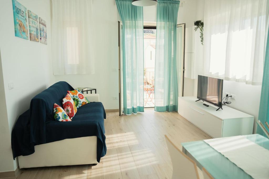 a living room with a blue couch and a tv at Roma Apartment in Sperlonga