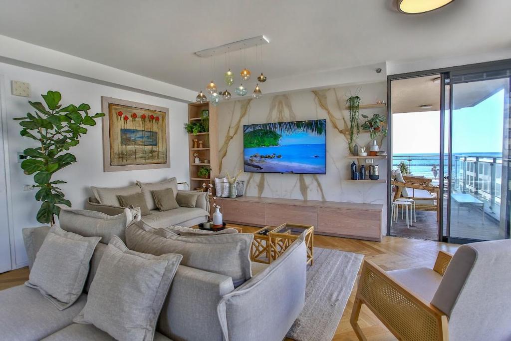 un soggiorno con divano e TV di Ultra Luxury 3BR Beach Apartment a Tel Aviv