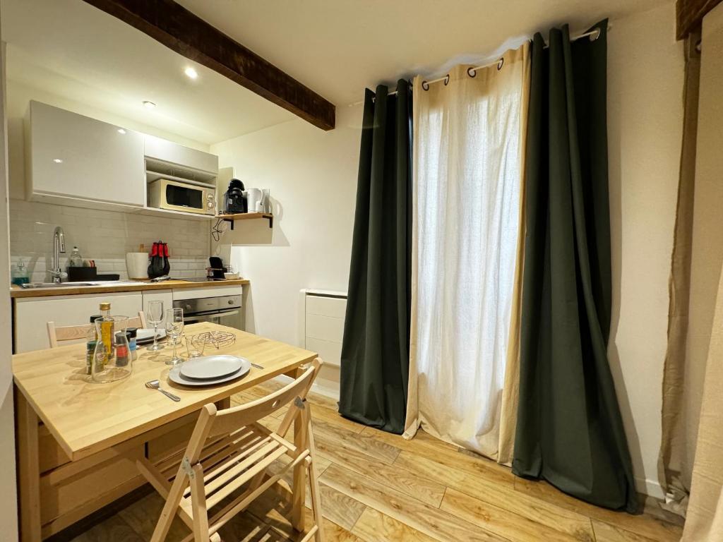 une cuisine avec une table et des chaises ainsi qu'une fenêtre dans l'établissement Le Pétramale - Cœur de ville - Navette Parking, à Avignon