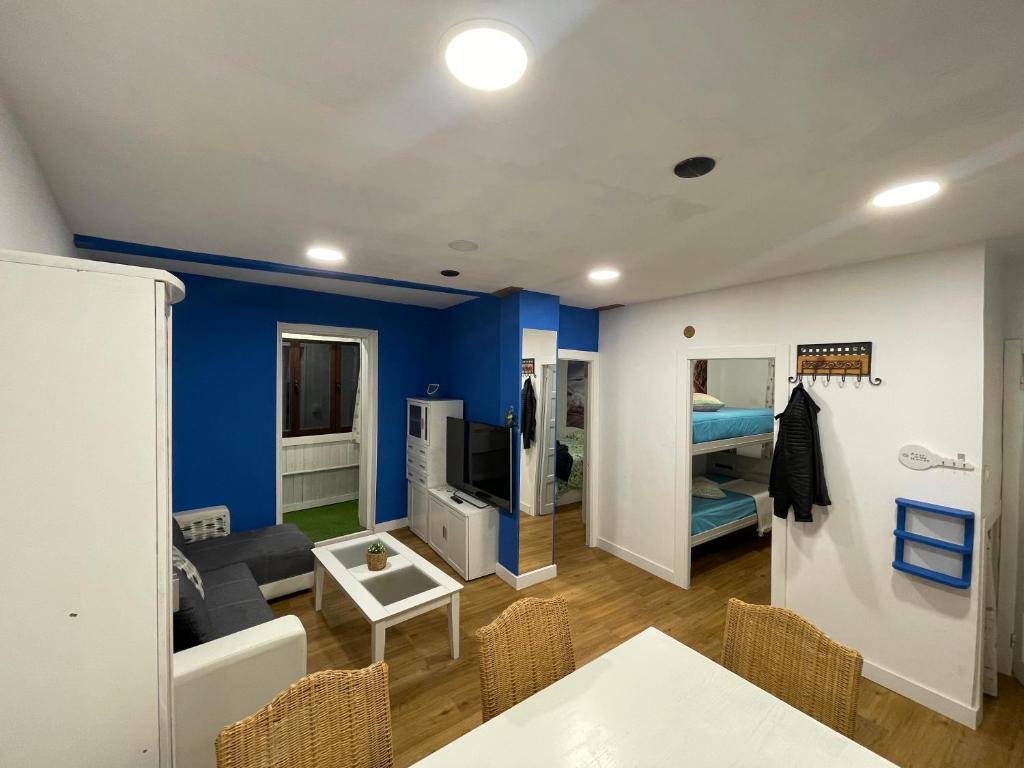 a living room with blue walls and a table and chairs at La Casa del Capitán in Ribadesella