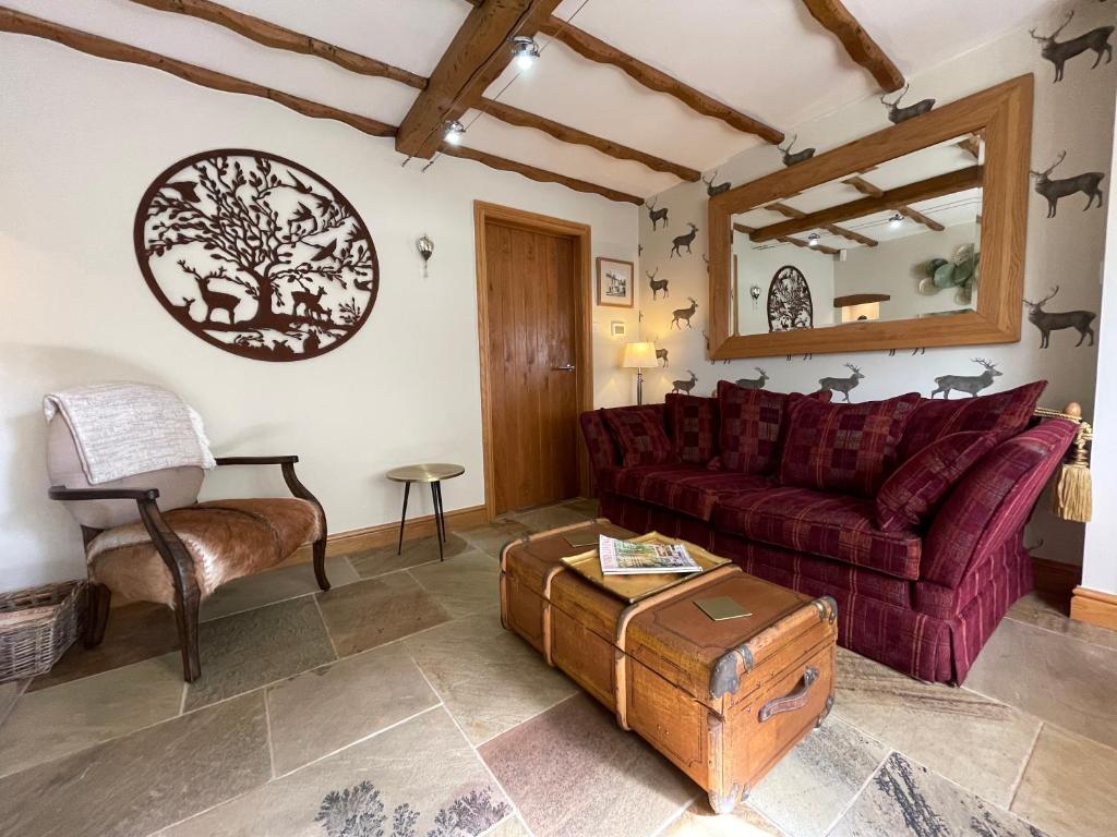 a living room with a red couch and a table at Beautiful Baslow Bolthole (close to Chatsworth) in Baslow