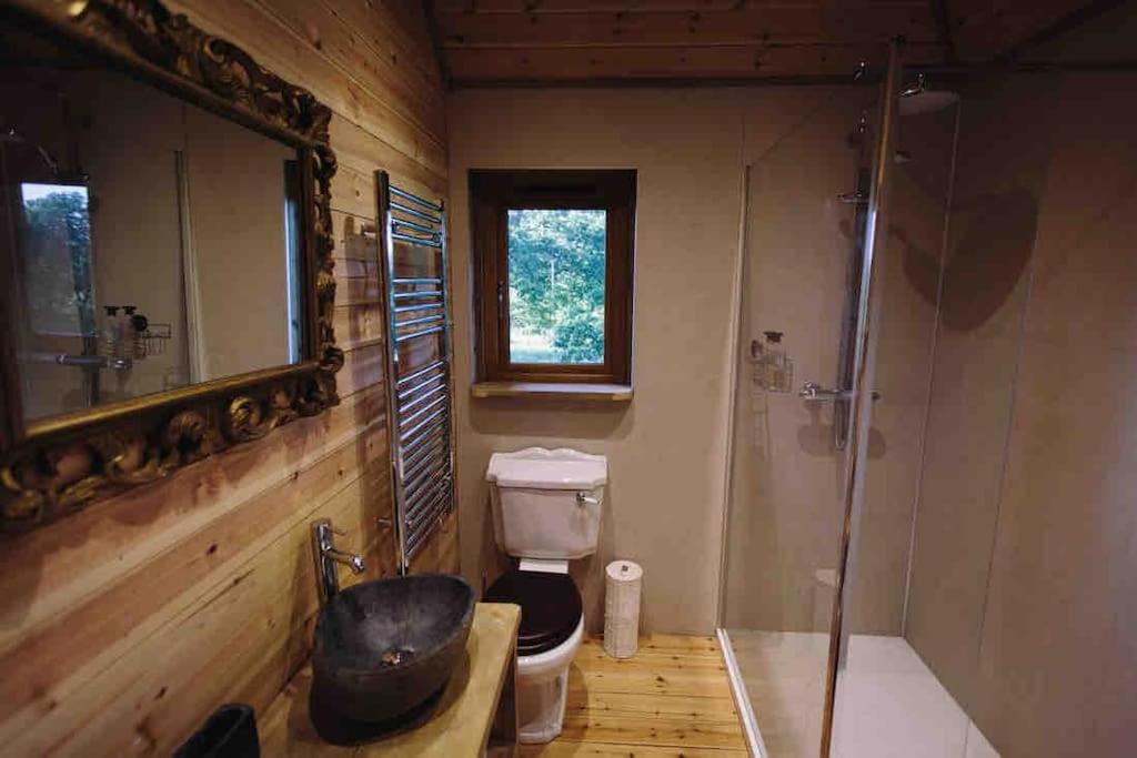 a bathroom with a toilet and a glass shower at The Treevilla in Protópappas