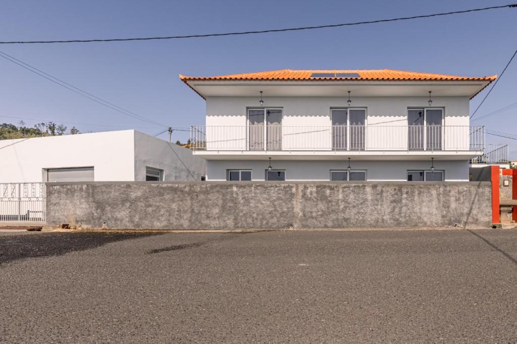 ein weißes Haus hinter einer Betonwand in der Unterkunft Villa Angela- Madeira Inn Group in Calheta