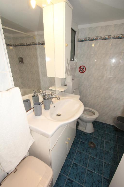 ein weißes Bad mit einem Waschbecken und einem WC in der Unterkunft Athens Centre Acropolis "Sunny" apartment #718 in Athen