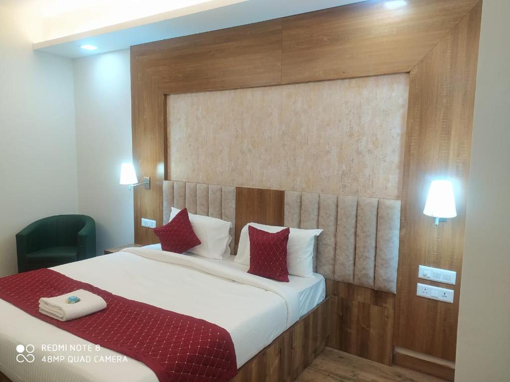 a bedroom with a large bed with red pillows at The Rose Manor By Iconic Delhi International Airport in New Delhi