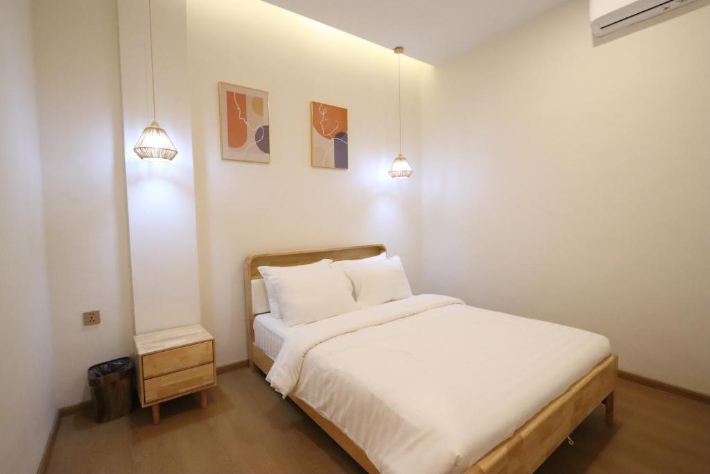 1 dormitorio con 1 cama blanca y 2 luces en Casabella 201 A2 Grand Batam Penuin Wet Market, en Nagoya