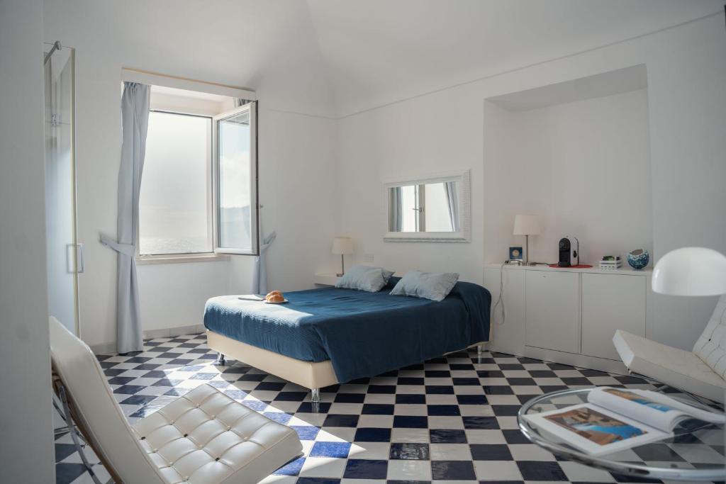 um quarto com uma cama azul e um piso xadrez em Ganimede Centro Storico em Sperlonga