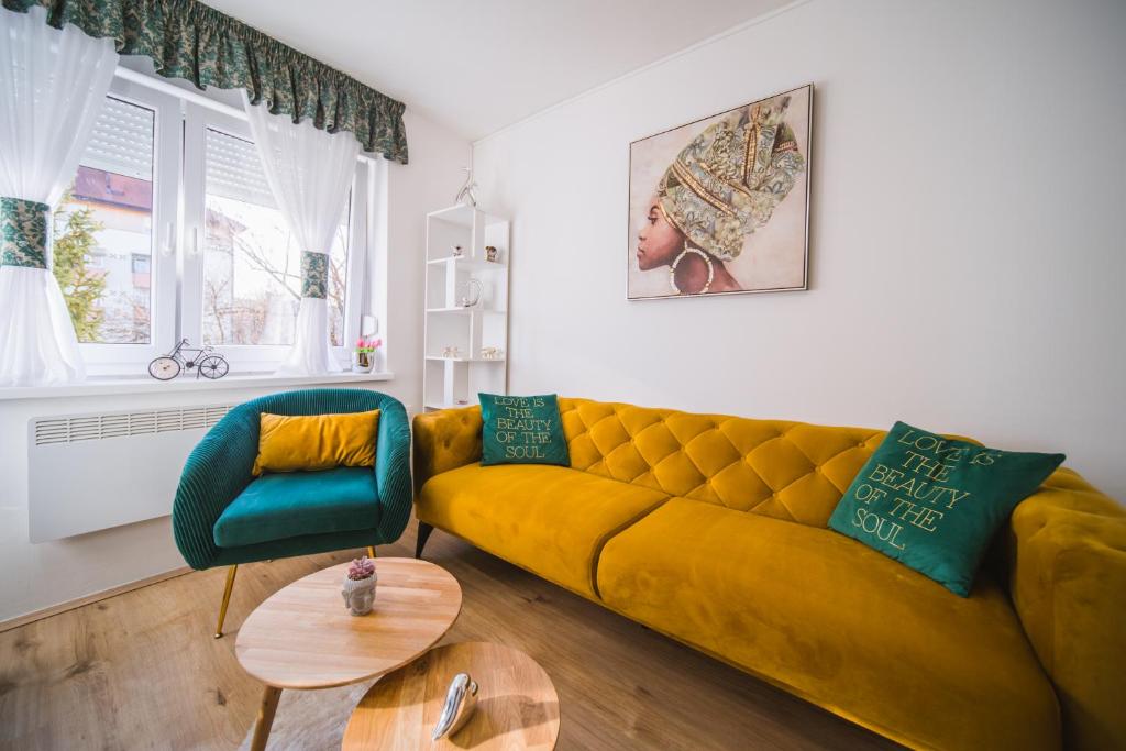 a living room with a yellow couch and a table at Apartment Sacramento centar Varaždin in Varaždin