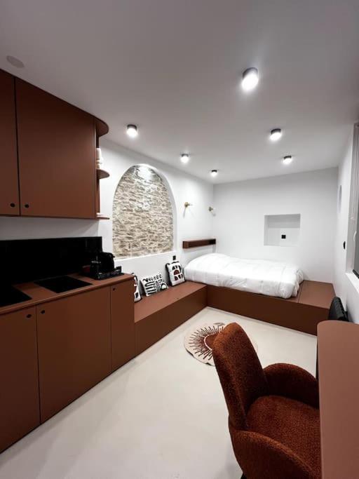 Il comprend une chambre avec un lit et une cuisine avec une chaise. dans l'établissement The Studio Family - Le Terracotta, à Dijon