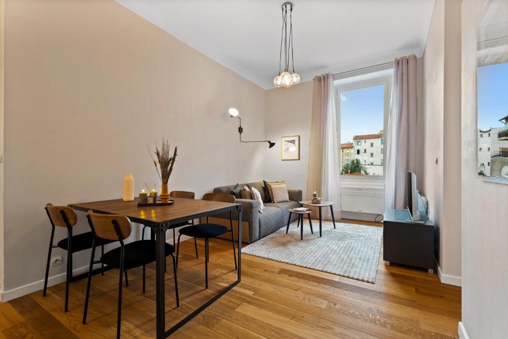 un salon avec une table et un canapé dans l'établissement Nice Renting - DABRAY - Chic & Spacious Apartment in the Heart of Nice - Prime Location Near Attractions, à Nice