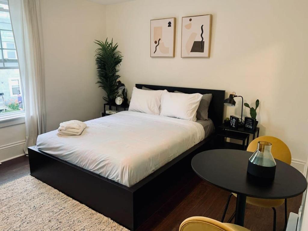 a bedroom with a black bed and a table at Pet-Friendly Lovely Studio #2, Balcony in Halifax