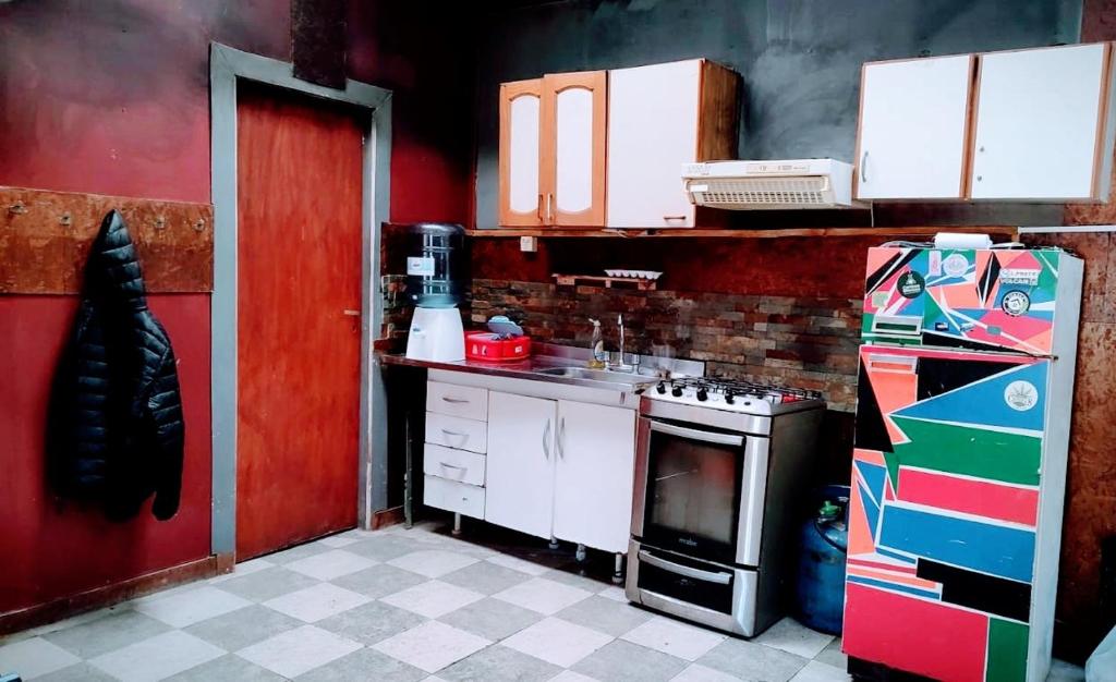 a kitchen with a stove and a red wall at Pali House in Ushuaia