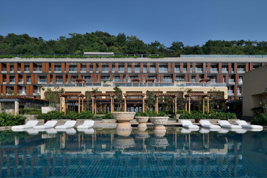 ein Hotel mit einem Pool vor einem Gebäude in der Unterkunft The Westin Resort & Spa Himalayas in Rishikesh