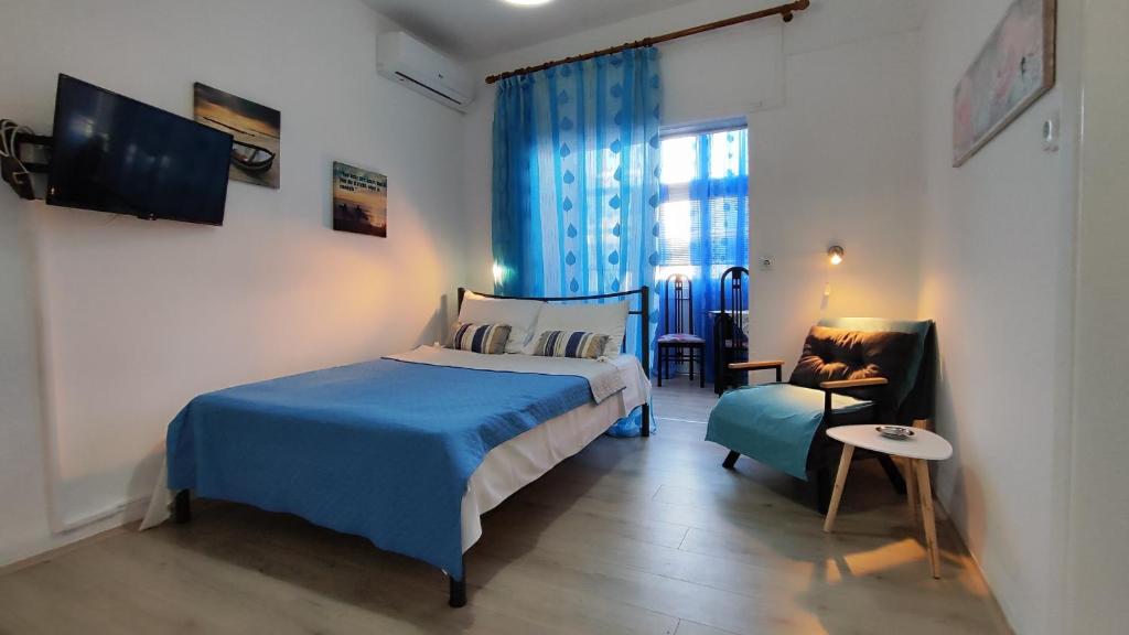 a bedroom with a blue bed and a chair at Economy apartment in Flogita
