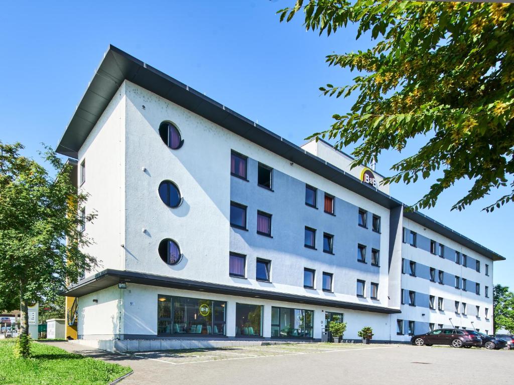 ein weißes Gebäude mit runden Fenstern darauf in der Unterkunft B&B Hotel Mainz-Hechtsheim in Mainz