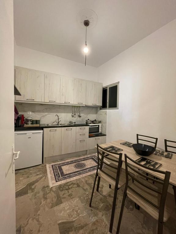 a kitchen with white cabinets and a table and chairs at KORONI MARE FRONT HARBOR in Koroni