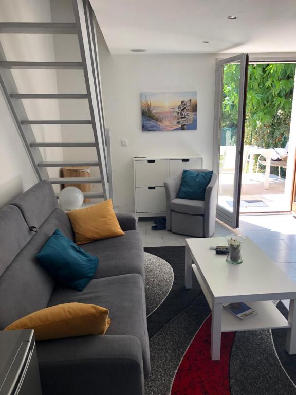 a living room with a couch and a table at Maison vacances jardin mer proche in Guérande