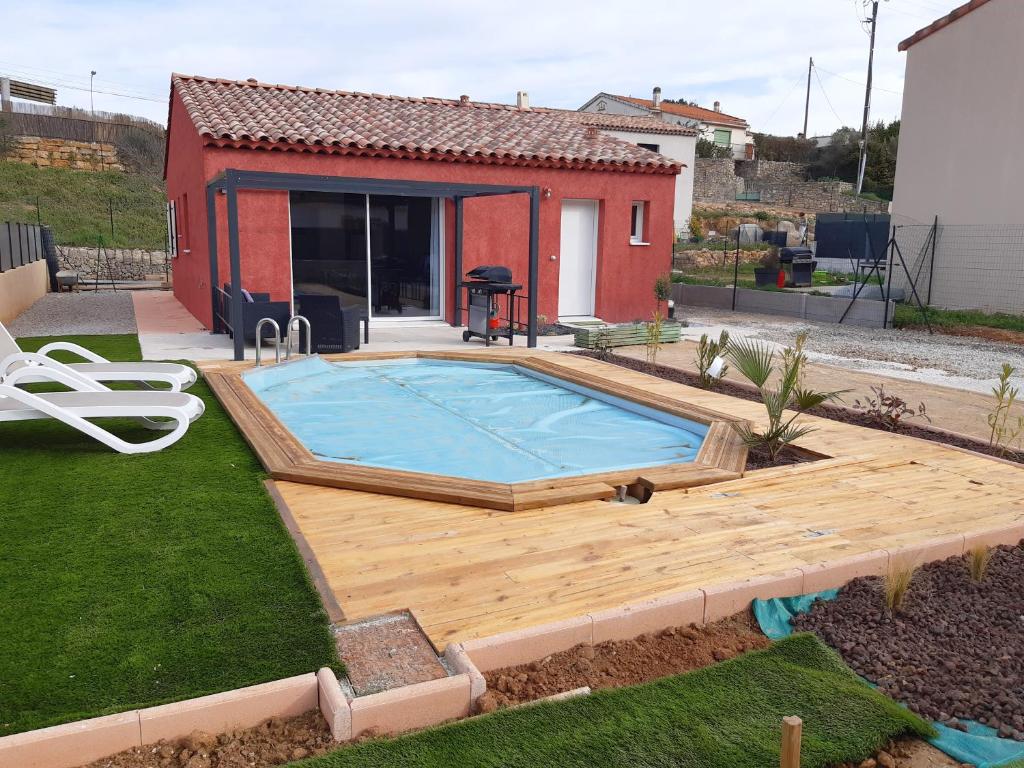 einem Pool mit Holzterrasse und einem Haus in der Unterkunft Carcès, Villa en Provence, piscine, 6 personnes. in Carcès