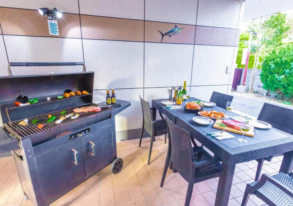 a kitchen with a grill and a table with food at 雨でも炭でBBQが出来る/プール付き!MAX12名/駐車2台可能! in Shirahama