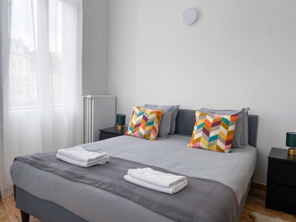 1 dormitorio con 1 cama con 2 toallas en New Cozy Apartments In Porte de HAL en Bruselas