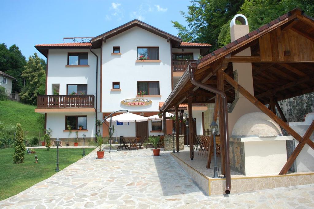 a large white building with a patio in front of it at Guest House Savina in Plachkovtsi