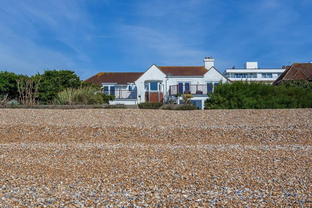 a house sitting on top of a rocky beach at Cooden Beach Corner - awesome views! in Bexhill