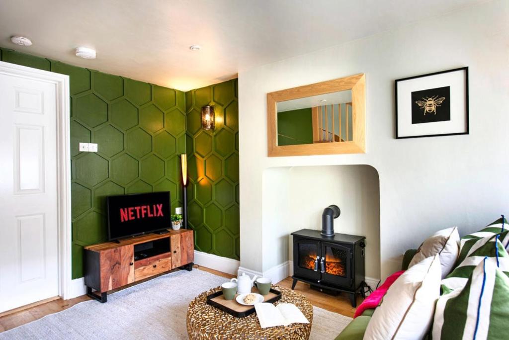 a living room with a tv and a fireplace at Cosy Cottage, Central Ludlow, Free Parking, Boutique Hotel Style in Ludlow