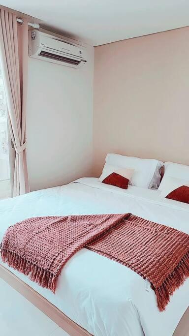 Un dormitorio con una cama con una manta roja. en 京都Kyoto Home 2BR - 53 Sqm at Downtown Semarang en Semarang