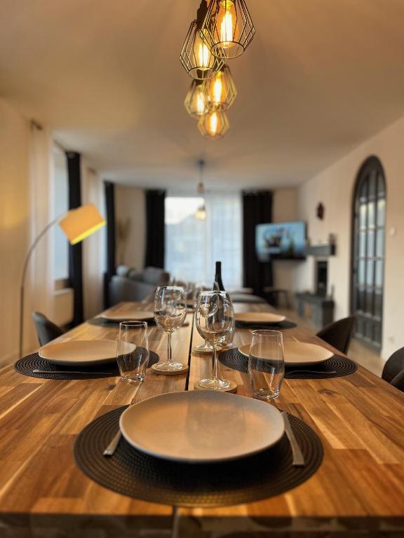 une table avec des assiettes et des verres à vin dessus dans l'établissement Appartement St Eloi 75m², à Saint-Dié-des-Vosges