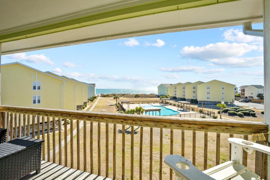 uma varanda com vista para uma piscina e edifícios em OceanScape- Beach, Pool, and Sun near the heart of Surf City! em Surf City