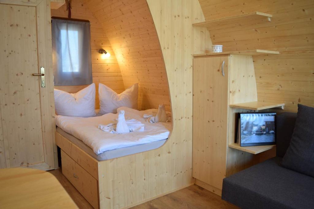 1 dormitorio con 1 cama en una habitación con TV en Schwimmpod an der Peene en Anklam